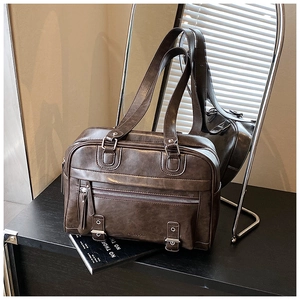 Macro detail of dark brown PU leather tote bag with metallic buckles and zipper pocket
