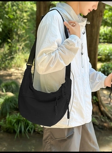 Detail of black nylon crescent crossbody bag with adjustable wide strap and zipper detail