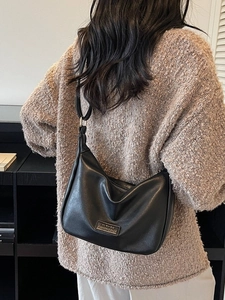 Minimalist black crescent shoulder bag in PU leather shown on model for daily commuting