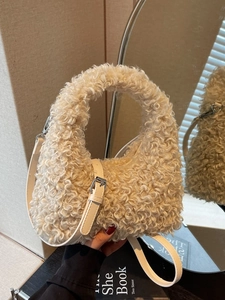 Chic beige faux shearling handbag with adjustable leather strap in a stylish interior