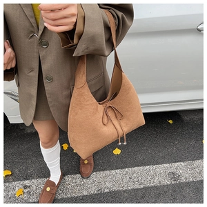 Detail of brown suede hobo bag featuring drawstring with silver metal sphere charms