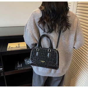 Detail of leopard print crossbody bag worn by model showing trendy textured design