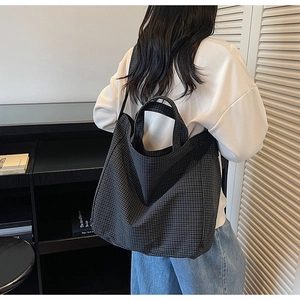 Detail of a large capacity tote bag with black and white checkered pattern and strap