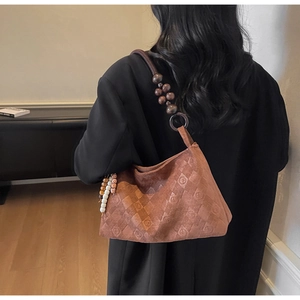 Brown suede underarm bag with vintage monogram and unique wooden bead shoulder strap