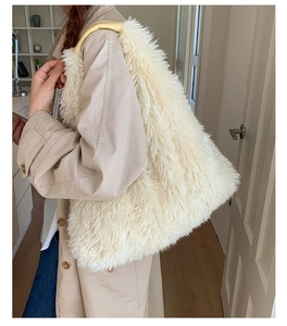 Side view of white faux fur tote bag with leather handles on a model in a minimal room