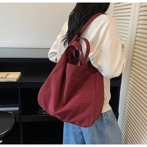 Detail of burgundy checked canvas tote bag featuring double handles and spacious design