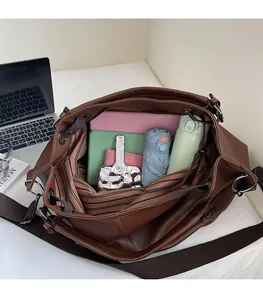 Interno spazioso della borsa tote in pelle marrone con tasche e oggetti quotidiani