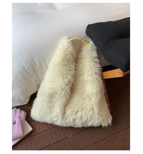 Detail of soft cream faux fur tote bag showing dense plush texture and curved handle