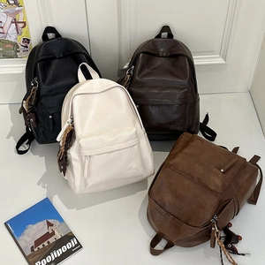 Detail of four retro leather backpacks with bear charms and fine grain texture