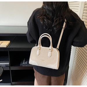 Detail of beige structured leather bag with twin handles and fashion logo print