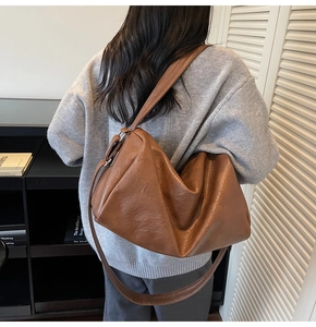 Close-up of brown soft leather tote bag with wide strap for daily commuting