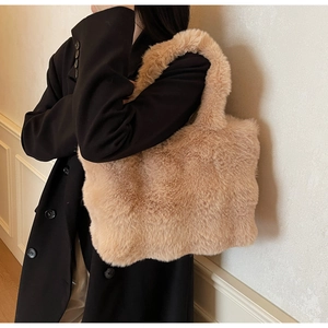 Détail d'un sac cabas en peluche beige montrant la texture douce et l'anse robuste