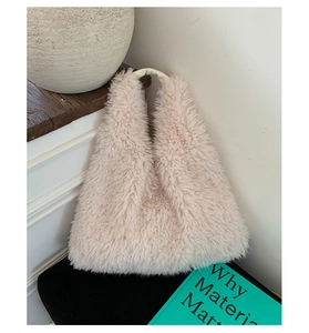 Close-up of soft beige plush faux fur texture and leather handle on a large tote bag