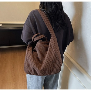 Détail des larges bretelles à carreaux marron d'un grand sac cabas en toile