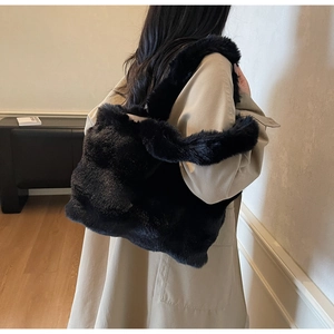 Détail d'un grand sac cabas en peluche noire montrant la texture douce et la bandoulière