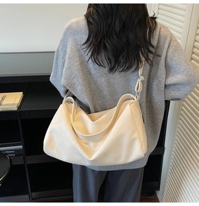 Detail of minimalist cream hobo bag with pebble texture and wide shoulder strap