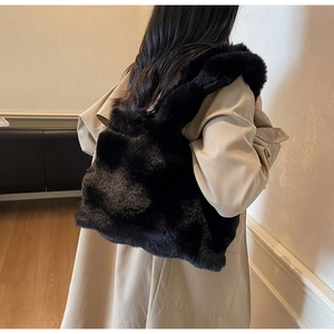 Détail d'un grand cabas en peluche noire montrant la texture douce de la fausse fourrure