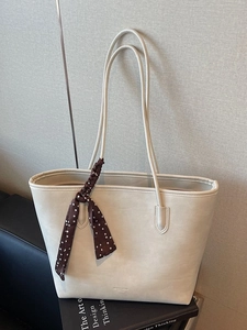 Large cream white faux leather tote bag with polka dot scarf on a minimalist background