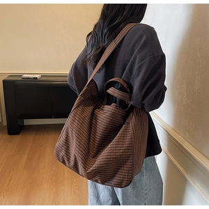 Brown plaid canvas tote bag shown from side back view on model for daily lifestyle use
