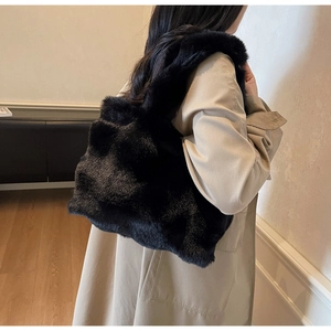 Gros plan sur la texture pelucheuse et la large bandoulière de ce sac cabas en fausse fourrure