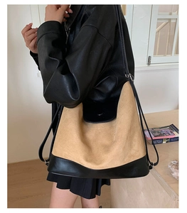 Detail of a large hobo shoulder bag featuring black leather and tan suede patchwork