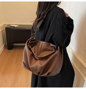 Détail du sac hobo marron à motif litchi avec une large bandoulière réglable