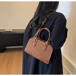 Fashionable leopard print handbag with brown leather trim shown from a back view