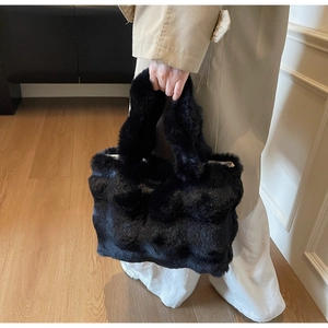 Détail du sac cabas noir en fausse fourrure avec poignée douce pour un style hivernal