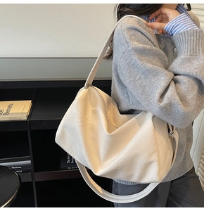 Detail of white soft leather hobo bag with adjustable wide strap and silver buckle