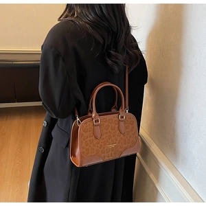 Close-up of leopard print pillow bag with dual handles and detachable shoulder strap