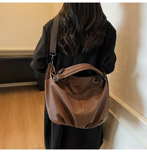 Vue détaillée du cuir grainé litchi texturé sur un grand sac cabas marron
