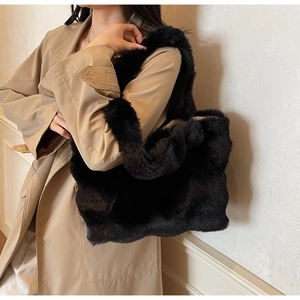 Détail d'un sac cabas en fausse fourrure noire montrant la texture sur l'épaule