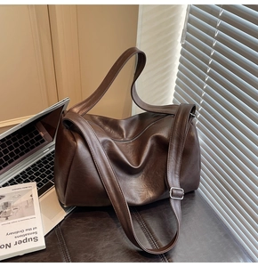 Detail view of the vintage brown leather tote bag with adjustable strap and metal buckle