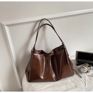 Deep coffee large tote bag in glossy leather shown with laptop and books on desk