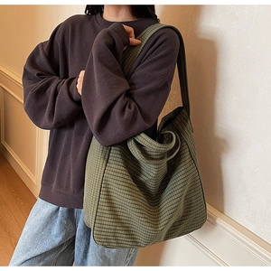 Detailed shot of olive green checkered canvas tote bag with a wide shoulder strap