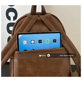 Brown leather backpack detail showing hidden back zipper pocket holding a tablet device