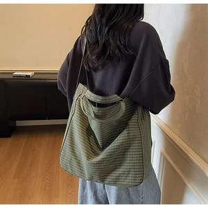 Close-up of green checkered canvas tote bag showing texture and dual strap design