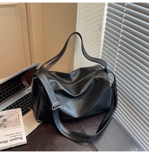 Macro detail of high-quality black faux leather tote with silver zipper and wide strap