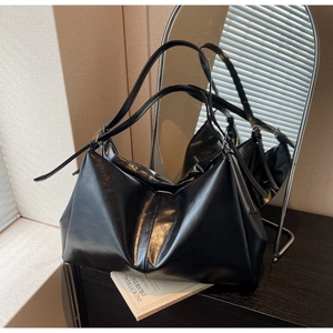 Detailed view of large black faux leather tote bag with glossy vintage crinkle texture