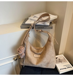 Detail view of khaki suede hobo bag with adjustable strap and bear charm decoration