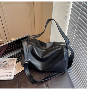 Detail of black matte PU leather tote bag featuring silver zipper and adjustable strap