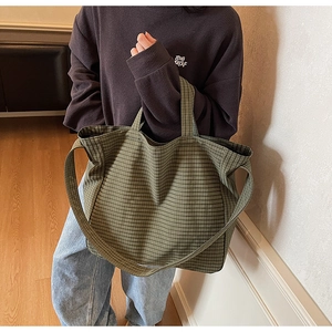 Detail view of large green checkered canvas tote bag showing its texture and capacity