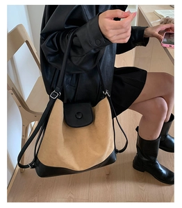 Detail of large tote bag showing khaki suede and black leather stitching with metal buckle