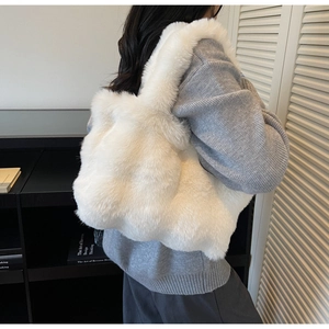 Détail d'un grand sac cabas en fausse fourrure blanche montrant sa texture douce