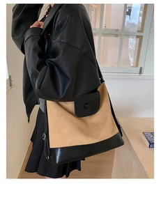 Detail view of khaki canvas tote bag with black leather flap and metallic ring closure
