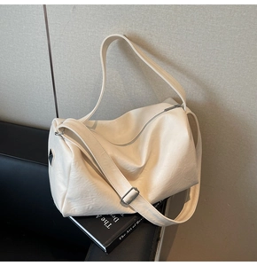 Close-up of cream soft faux leather tote bag showing fine texture and wide strap