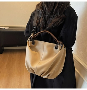 Vue de dos d'un mannequin portant un grand sac cabas en cuir beige texturé