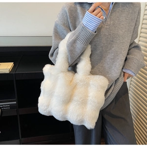 Détail d'un sac cabas en peluche blanche douce montrant la poignée et la texture