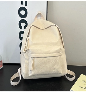 Detail of soft cream PU leather texture and embroidered logo on retro casual backpack