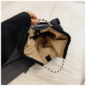 Detail view of the black quilted tote bag with internal zip pocket and magnetic closure